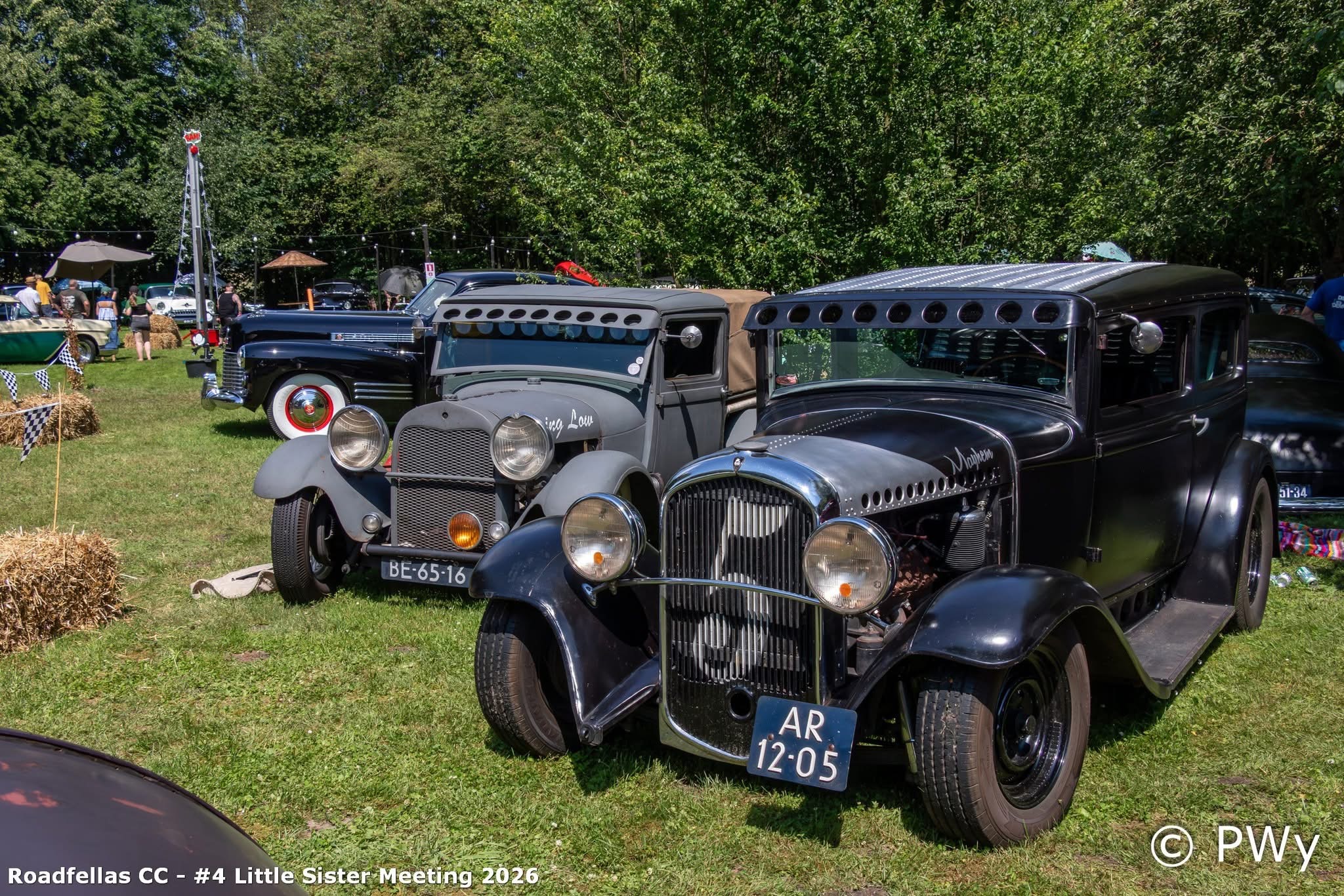 Hot rods en rat rods geparkeerd voor het witte gebouw van Wit Kerkje