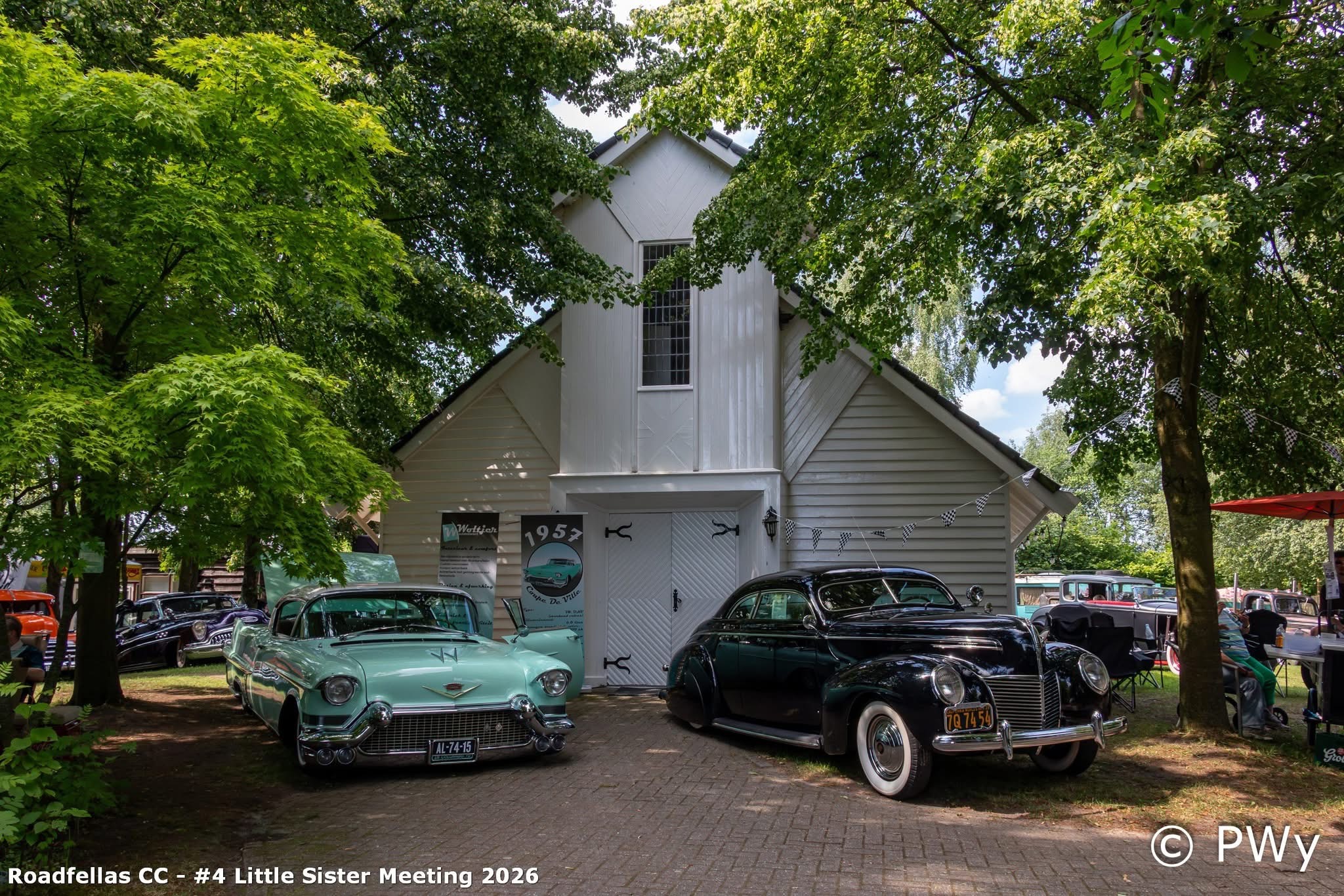 Wit kerkje met turquoise Cadillac Coupe De Ville 1957 en zwarte classic naast de deur