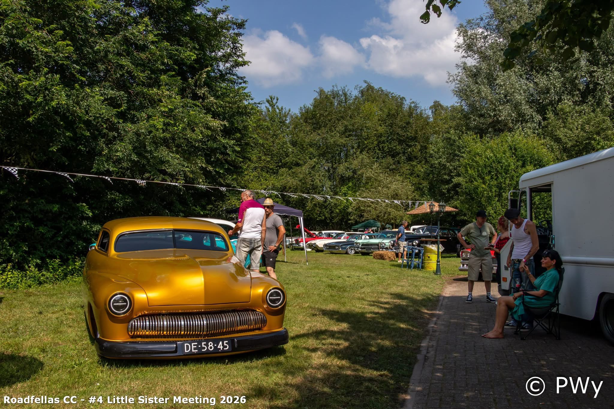 Gouden Mercury lead sled en turquoise Cadillac naast een witte foodtruck bij Wit Kerkje